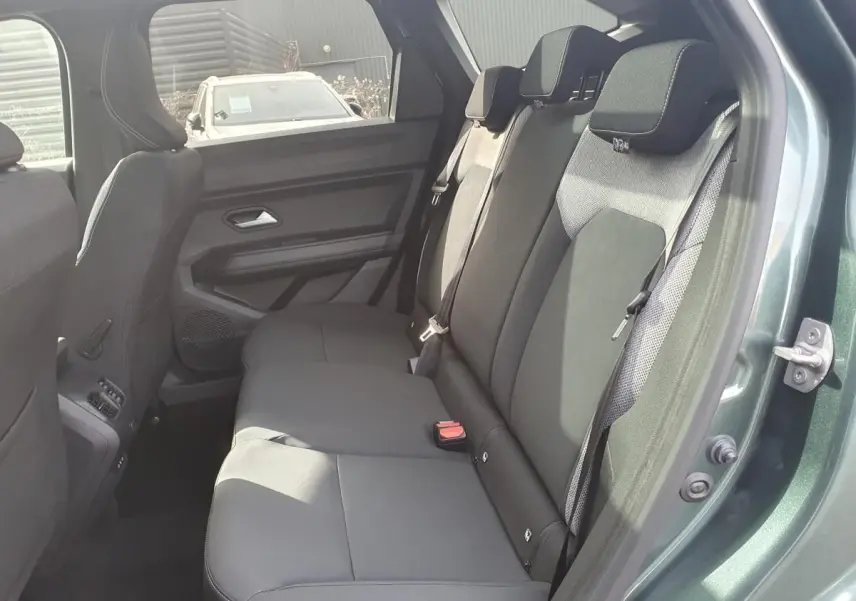 Vue côté droit sur la banquette arrière noire du Dacia Bigster vert cèdre avec ceinture et appuie-têtes visibles.