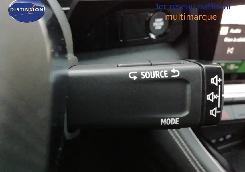 Gros plan sur la commande au volant du Renault Austral noir étoile métal, montrant les boutons source et mode.