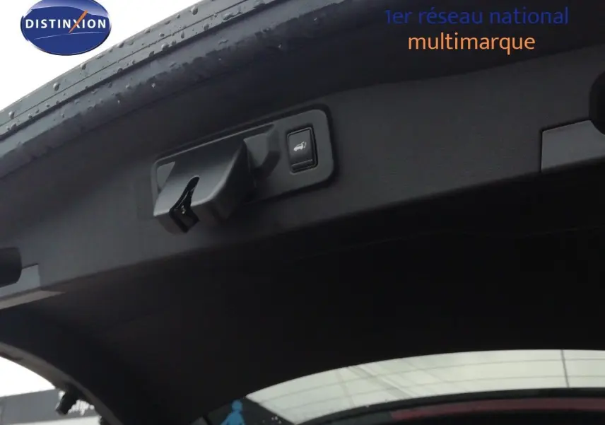 Détail du hayon ouvert du Renault Austral noir étoile métal montrant la commande d'ouverture électrique et le bouton de fermeture.