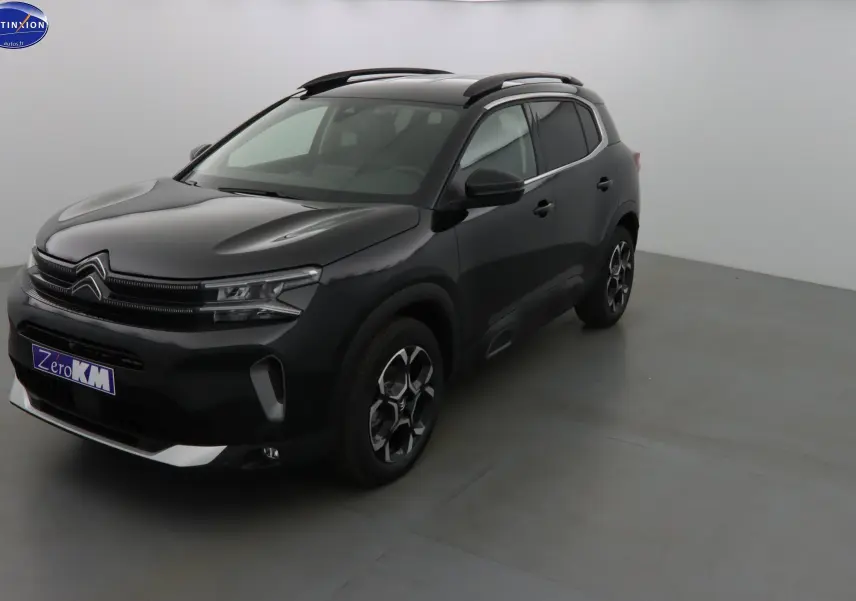 Citroën C5 Aircross noir métal en 3/4 avant droit, avec jantes bi-ton et barres de toit visibles.