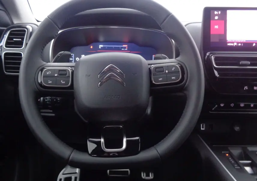 Vue rapprochée du volant noir du Citroën C5 Aircross 2022 avec commandes intégrées et tableau de bord numérique.