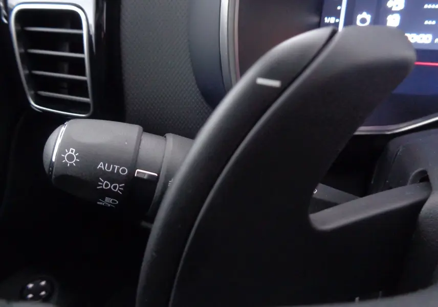 Gros plan sur la commande des phares à gauche du volant du Citroën C5 Aircross noir métal, intérieur moderne.