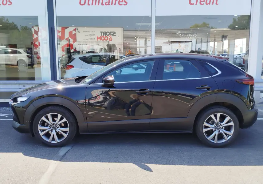 Profil côté gauche d'un Mazda CX-30 noir 2020, mettant en valeur ses lignes fluides et ses jantes alliage 18 pouces.