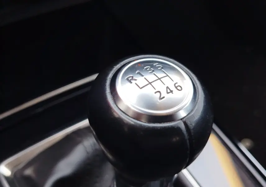 Gros plan sur le pommeau de la boîte manuelle du Mazda CX-30 noir, affichant les six vitesses et la marche arrière.