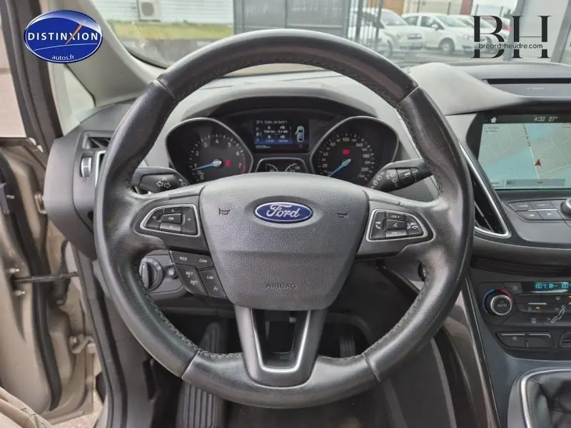 Vue centrée sur le volant cuir multifonction d'une Ford C-MAX 2018 avec tableau de bord et écran tactile visible