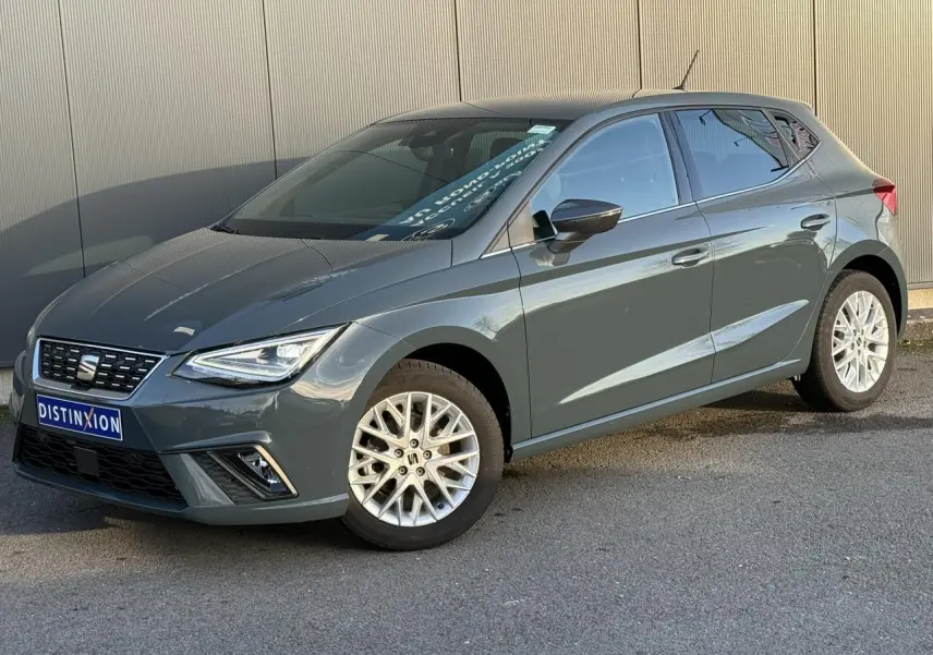 Vue 3/4 avant droite d'une SEAT Ibiza gris métallisé avec jantes alliage et calandre noire au logo centré.