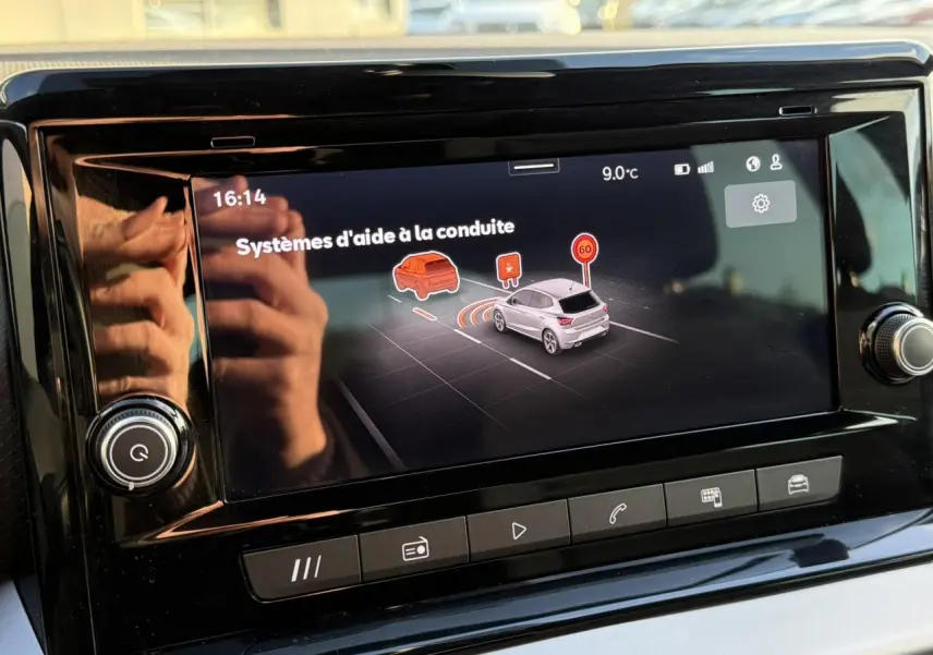 Écran tactile central du tableau de bord de la SEAT Ibiza bleu Fjord affichant les aides à la conduite.