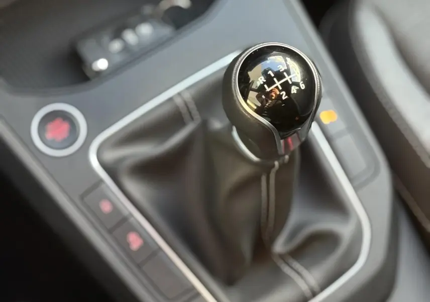 Gros plan sur le levier de vitesses manuel noir avec coutures blanches de la SEAT Ibiza TSI 115 Xcellence 2025.