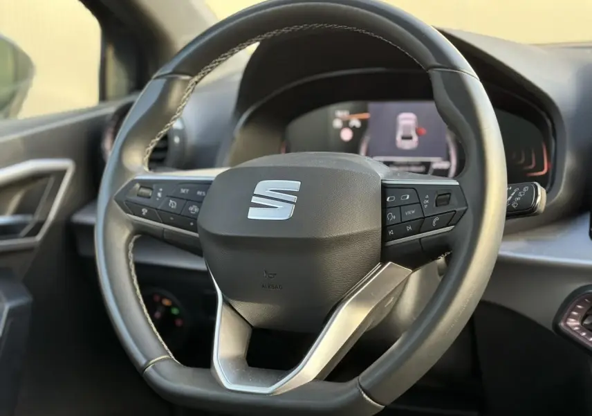 Volant sport cuir multifonction de la SEAT Ibiza TSI 115 Xcellence 2025, vue rapprochée de face sur intérieur noir.