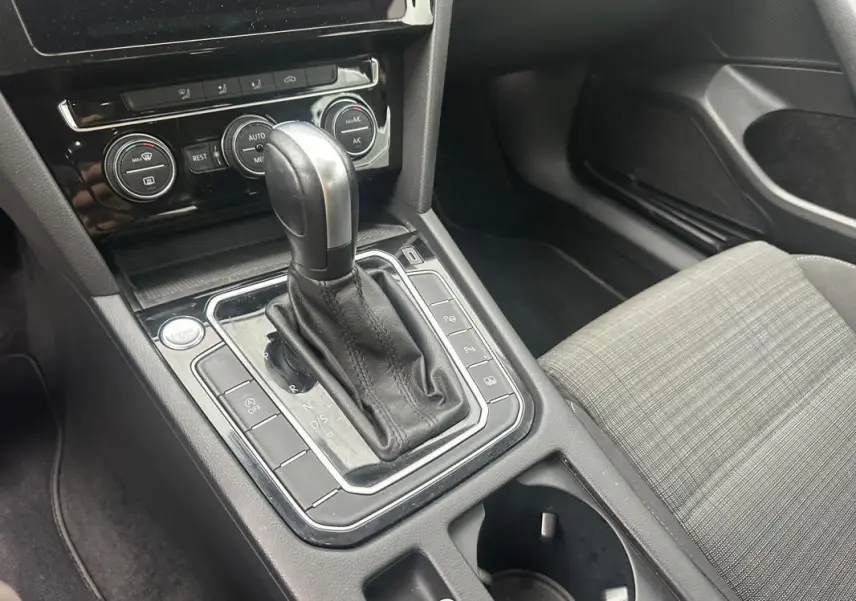 Vue rapprochée de la console centrale de la Volkswagen Passat Business 2021 avec levier de vitesse automatique et sièges gris à motifs.