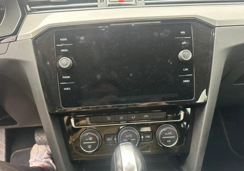 Tableau de bord et console centrale de la Volkswagen Passat Business 2021, avec écran tactile et commandes climatisation.