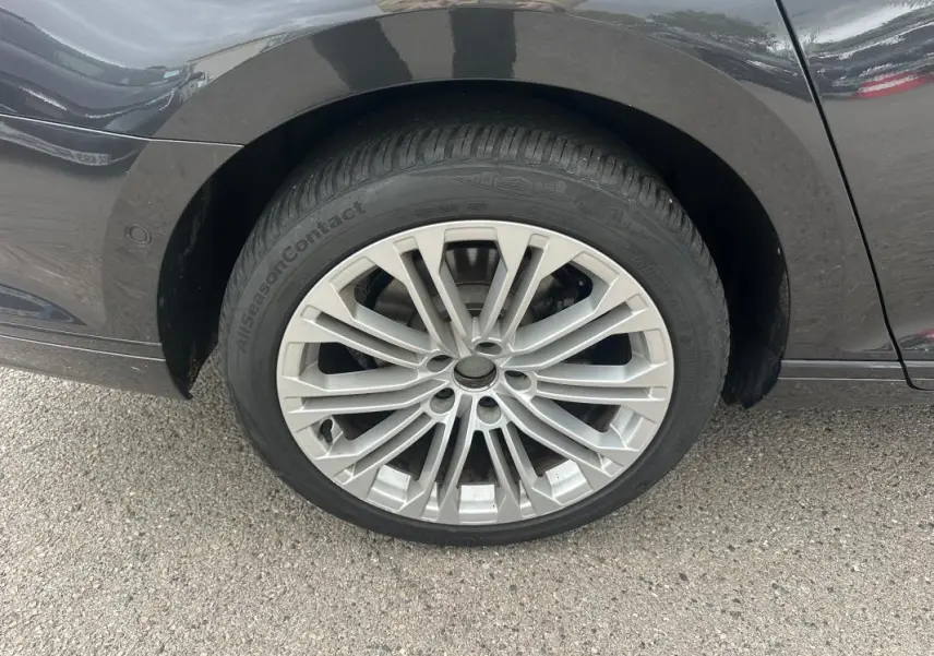 Gros plan sur la roue avant gauche de la Volkswagen Passat Business gris foncé avec jante alliage 17 pouces multi-branches.