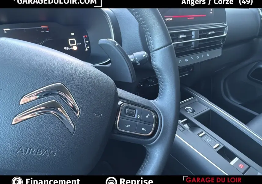 Vue rapprochée du volant cuir noir et tableau de bord central du Citroën C5 Aircross 2025 en intérieur.