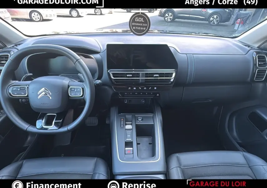 Intérieur noir du Citroën C5 Aircross 2025, vue frontale sur le tableau de bord et volant cuir multifonctions.