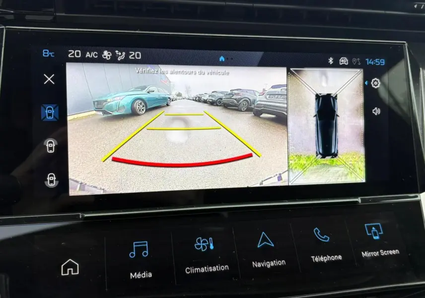 Écran tactile montrant la caméra 360° avec vue arrière et vue aérienne d’une Peugeot 308 SW gris Artense.