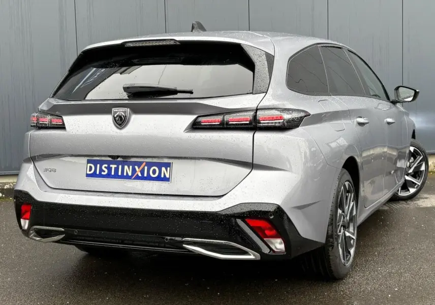Vue 3/4 arrière droite d'une Peugeot 308 SW Hybrid gris Artense avec feux LED et jantes alliage 17 pouces.