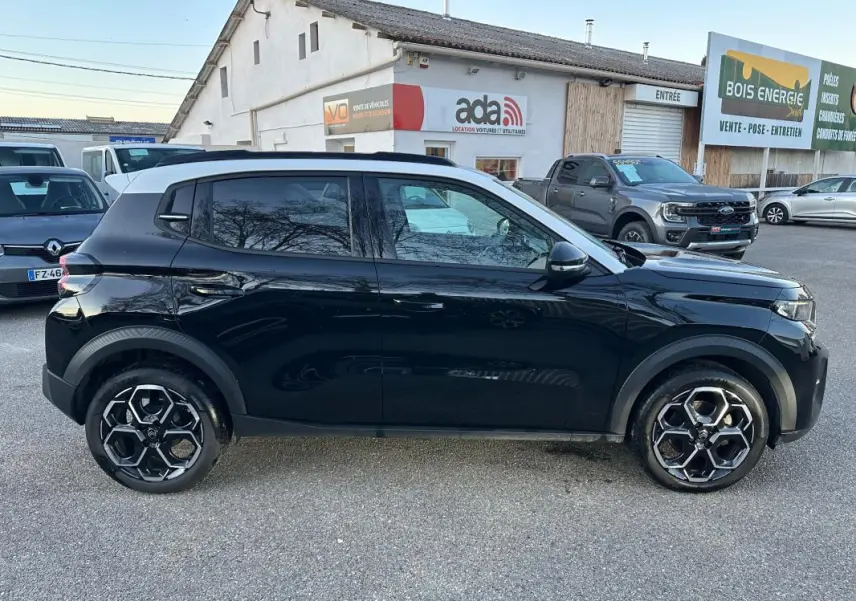 Vue de profil côté gauche d'une Citroën C3 noire 2025 avec jantes alliage 17 pouces et barres de toit visibles.