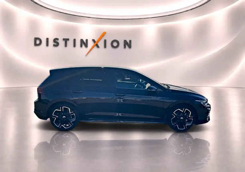 Profil droit d'une Volkswagen Golf noire 2026 R-Line avec jantes noires et décorations sportives, en studio lumineux.