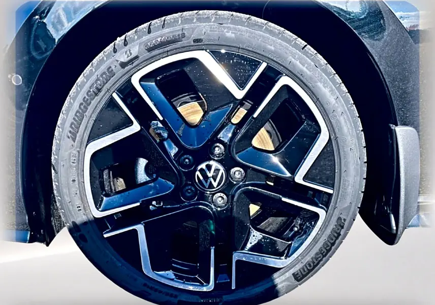 Gros plan sur la roue avant droite noire avec jante alliage noir et argentée de la Volkswagen Golf 1.5 etsi evo2 150 R-Line.