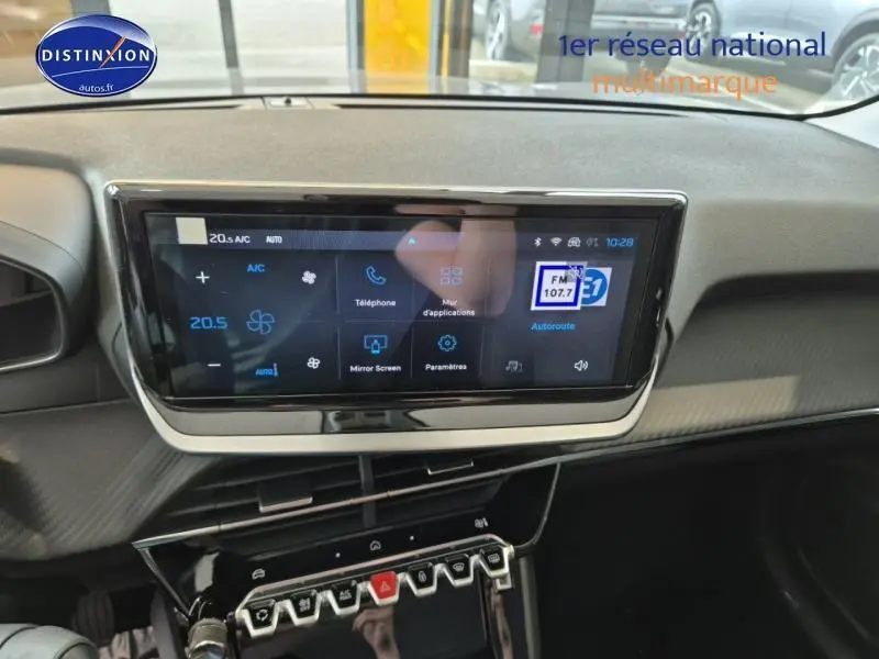 Écran tactile central et tableau de bord de la Peugeot 208 1.2 100ch Allure en gris Artense, vue intérieure frontale.