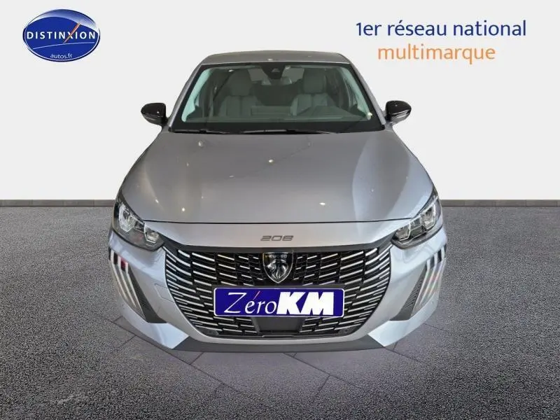 Vue frontale d'une Peugeot 208 1.2 100ch S&S Allure gris Artense avec calandre noire et logo lion visible.