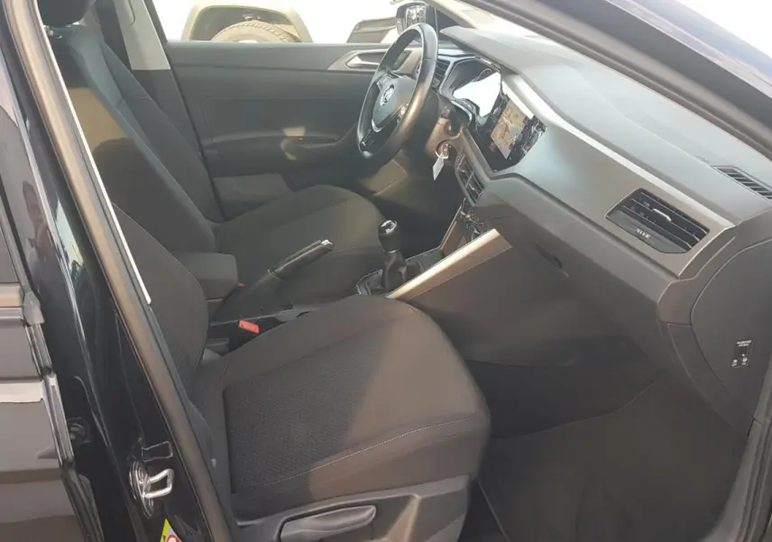 Intérieur noir de la Volkswagen Polo 2018, vue côté conducteur avec volant multifonctions et boîte manuelle.