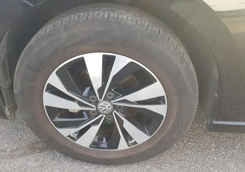 Gros plan sur la jante alliage bicolore noire et argentée d'une Volkswagen Polo noire, côté avant droit.