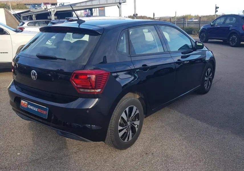 Volkswagen Polo noir vue 3/4 arrière droit, avec jantes alliage 15 pouces et feux arrière distinctifs.