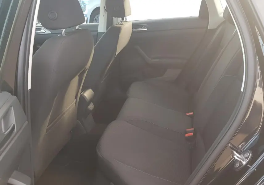 Vue intérieure arrière côté droit de la Volkswagen Polo noire 2018 montrant les sièges arrière en tissu et la portière ouverte.