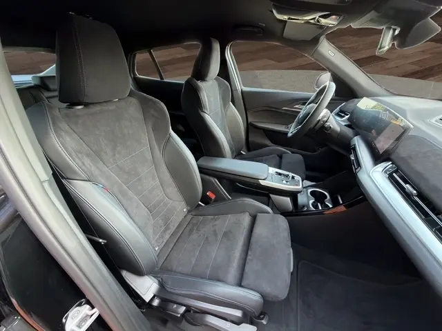 Vue intérieure côté gauche du BMW X2 sDrive20d M Sport 2025, sièges en alcantara noir et volant multifonctions alu-cuir.