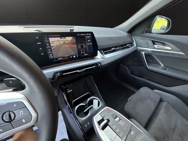 Vue intérieure côté conducteur du BMW X2 sDrive20d M Sport 2025 noir, avec écran tactile central affichant la caméra de recul.
