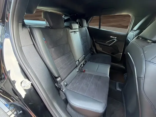 Vue intérieure côté droit des sièges arrière en cuir et alcantara du BMW X2 sDrive20d M Sport DKG7 noir 2025.