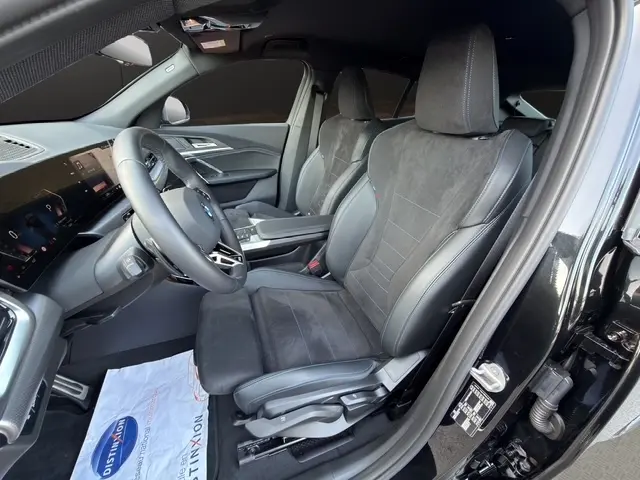 Vue intérieure côté conducteur de la BMW X2 sDrive20d M Sport noire, sièges sport en cuir et alcantara, volant multifonctions.