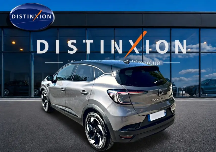 Renault Captur gris cassiopée en 3/4 arrière droit, avec feux LED et jantes alliage noires devant showroom Distinxion.