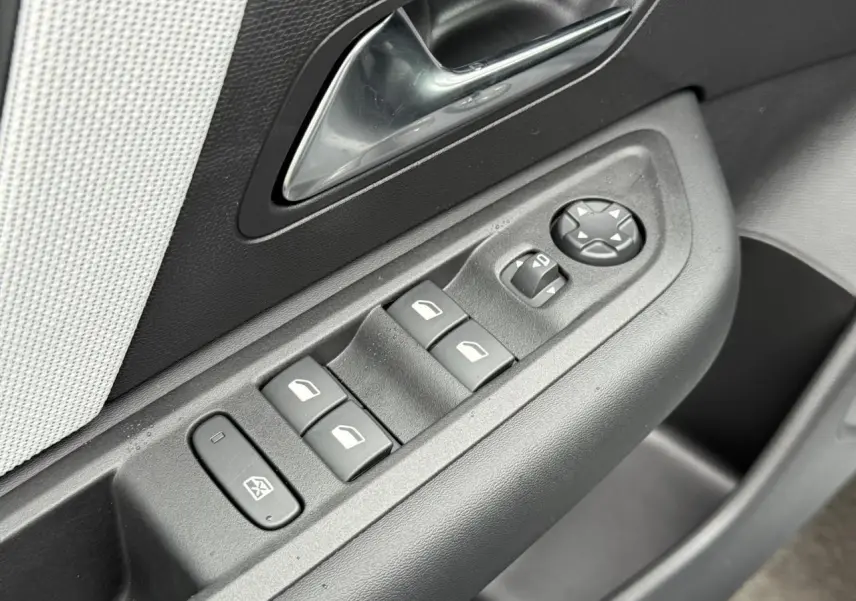 Gros plan sur les commandes de lève-vitres et réglage des rétroviseurs côté conducteur d'une Citroën C4 2025.