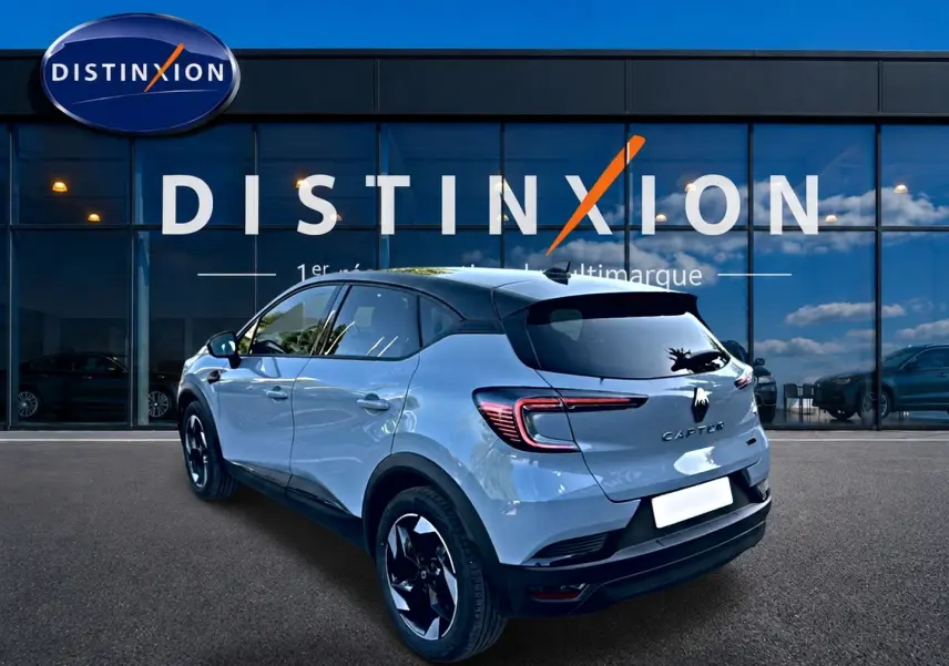 Renault Captur 1.8 e-tech gris rafale en 3/4 arrière droit, avec toit noir et jantes alu noires.