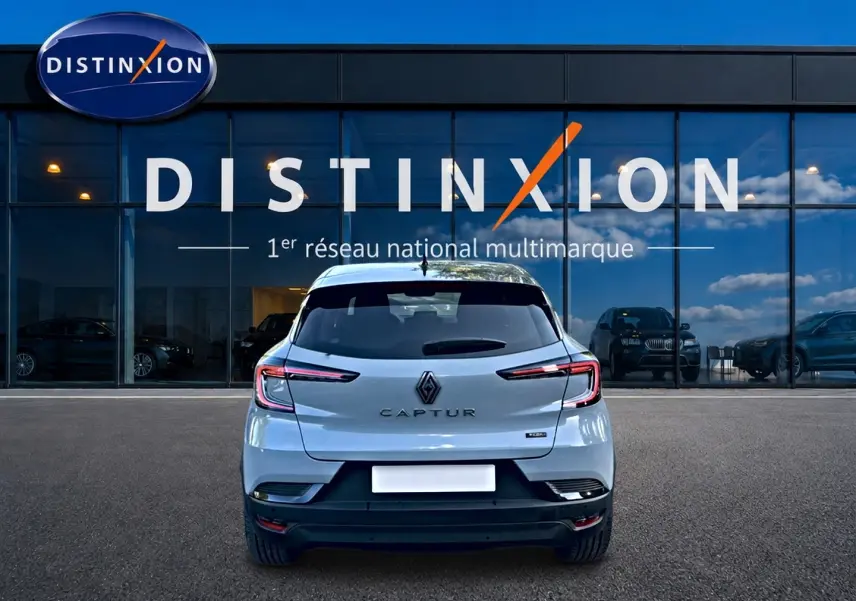 Vue arrière du Renault Captur gris rafale 2026, avec feux arrière LED et logo distinctif visible devant un showroom Distinxion.