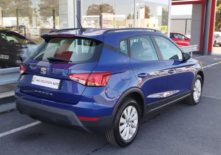 SEAT Arona bleu électrique vue 3/4 arrière droit, avec feux arrière LED et jantes alliage blanches.