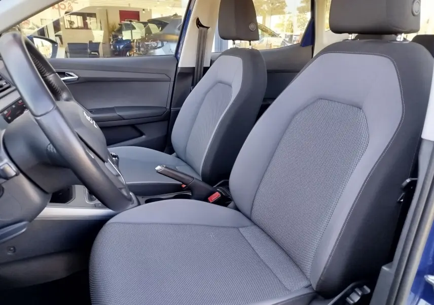 Vue intérieure côté conducteur du SEAT Arona bleu électrique 2019, sièges gris et volant multifonction.
