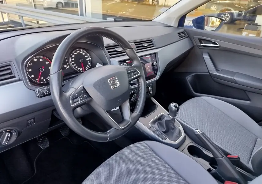 Intérieur de la SEAT Arona 2019 vu côté conducteur, volant multifonction, tableau de bord et sièges gris.