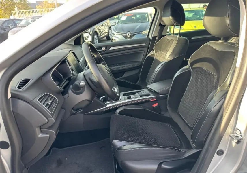 Intérieur côté conducteur de la Renault Mégane Break gris clair, sièges cuir et alcantara, tableau de bord moderne.