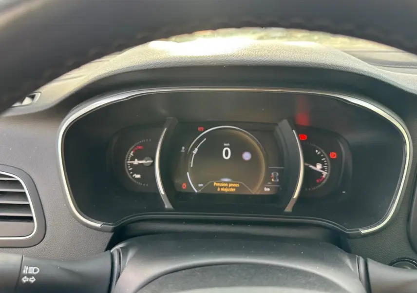 Tableau de bord numérique de Renault Mégane Break gris clair, affichant la vitesse à 0 km/h et alertes visibles.