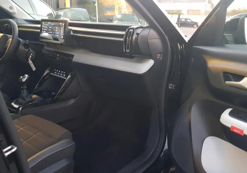Vue intérieure côté conducteur de la Citroën C3 noire 2025, avec tableau de bord moderne et écran tactile central.