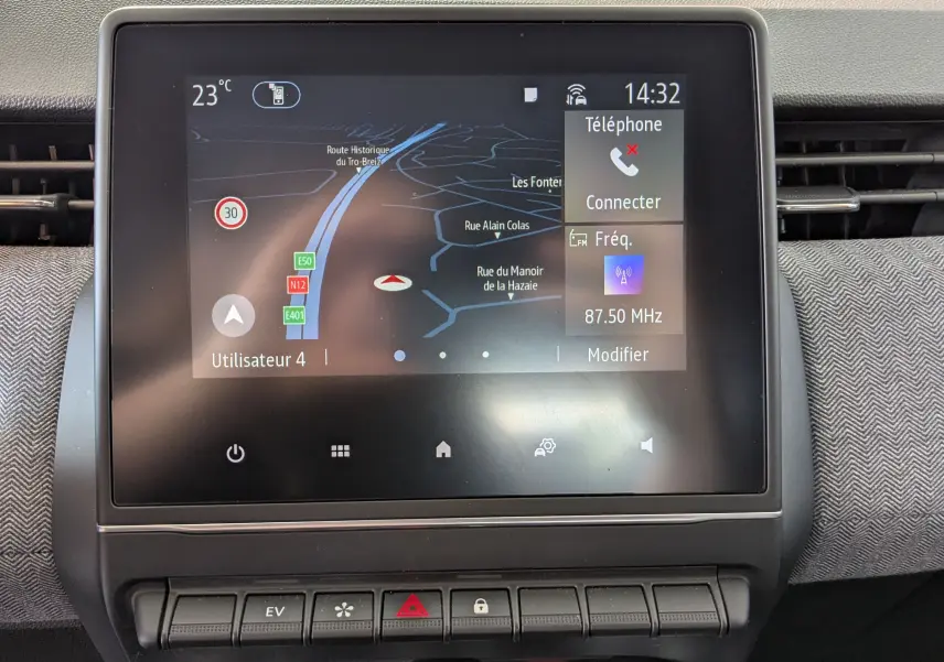 Écran tactile central de la Renault Clio gris schiste, affichant la navigation et les options multimédias, vue de face.
