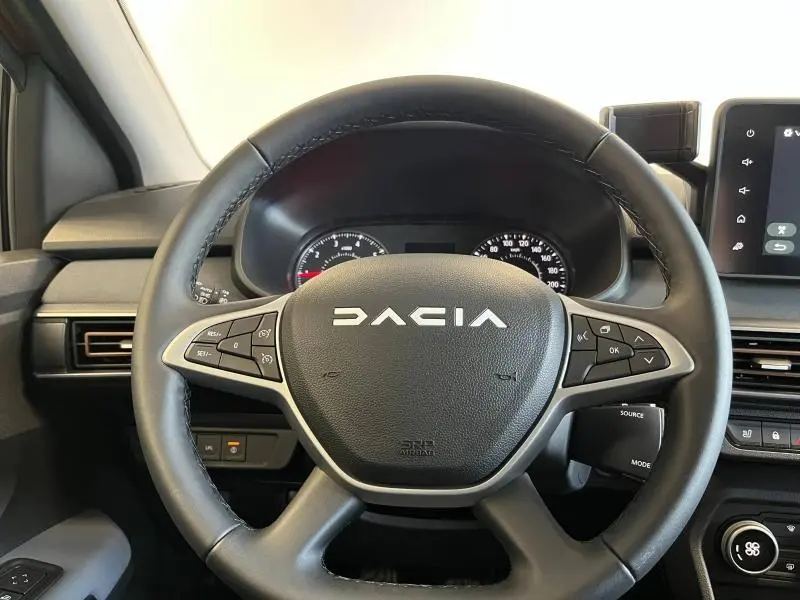 Vue rapprochée du volant noir avec commandes intégrées du tableau de bord du Dacia Jogger 2024.