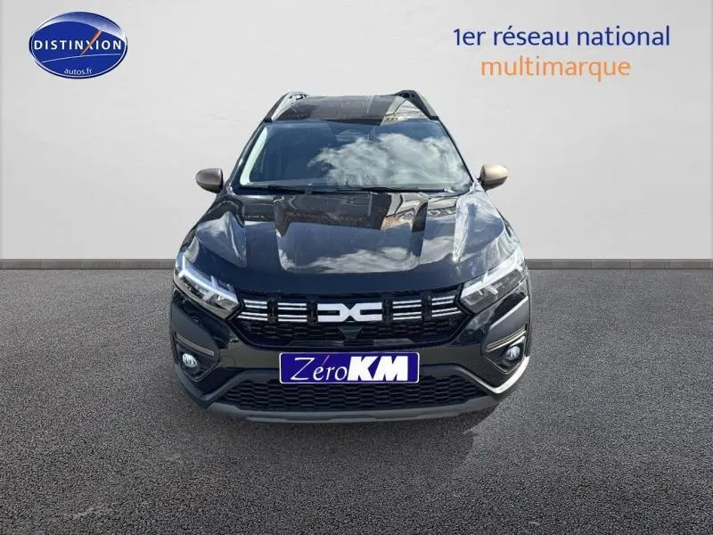 Vue avant d'un Dacia Jogger noir nacré métallisé avec calandre distinctive et phares LED allumés.