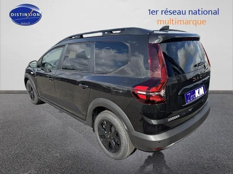 Vue 3/4 arrière droite du Dacia Jogger noir nacré métallisé avec barres de toit et jantes alu noires.