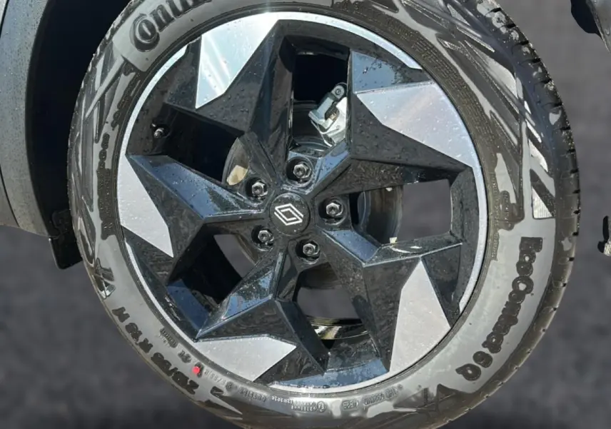 Gros plan sur la jante alu noire et gris argent du Renault Captur 2026, avec logo Renault central visible.
