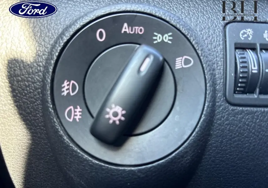 Commande des phares en gros plan sur tableau de bord noir d'un Volkswagen Tiguan beige 2010, version 1.4 TSI Carat.