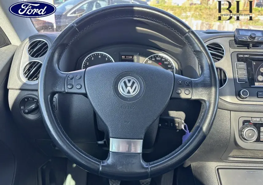 Vue rapprochée du volant cuir multifonction noir et du tableau de bord d’un Volkswagen Tiguan 2010.
